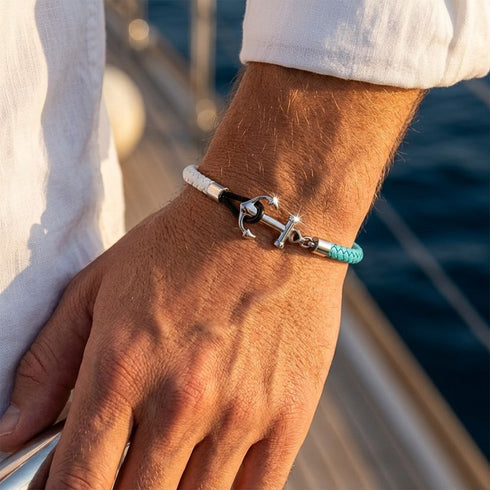 Maritimes Herren Ankerarmband mit Edelstahl Anker und blau weißem Segeltau am Handgelenk am Meer