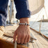 Herren Ankerarmband mit Edelstahl Anker und blau weißem Segeltau auf einer Yacht getragen