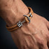 Detailaufnahme eines Herren Ankerarmbands mit braunem Leder, Edelstahl Anker und maritimem Design am Handgelenk