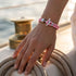Herren Ankerarmband mit rosa Leder und Edelstahl Anker im maritimen Stil am Handgelenk auf einem Boot