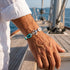 Herren Ankerarmband mit Edelstahl Anker und türkisfarbenem Segeltau auf einer Yacht im maritimen Stil
