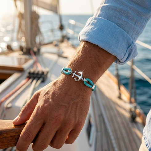 Herren Ankerarmband mit Edelstahl Anker und türkisfarbenem Segeltau beim Tragen auf einer Yacht am Meer