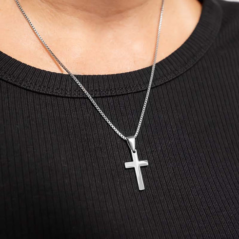 Dezente Edelstahl Kreuz Halskette getragen auf schwarzem Oberteil uniqal