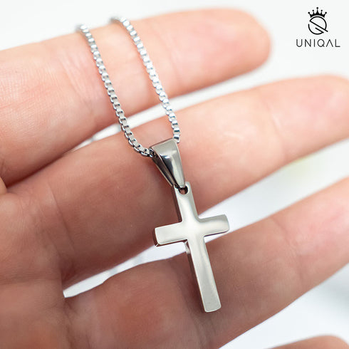 Kleines Edelstahl Kreuz an Kette, gehalten in der Hand uniqal