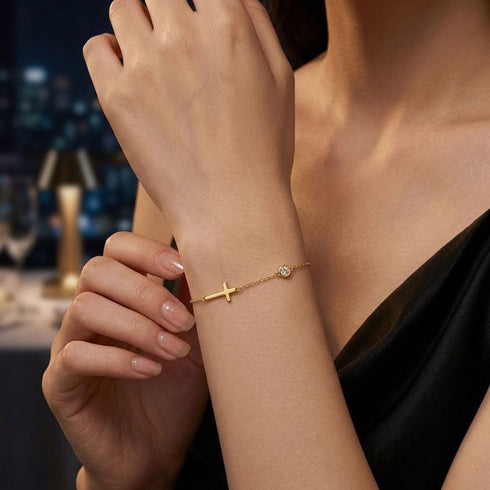 GRACE 14K GOLD Moissanit-Armband von UNIQAL mit klarer Kreuzform und zarter Silhouette als stilvoller Akzent zum schwarzen Outfit.
