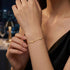 GRACE 14K GOLD Moissanit-Armband von UNIQAL mit klarer Kreuzform und zarter Silhouette als stilvoller Akzent zum schwarzen Outfit.