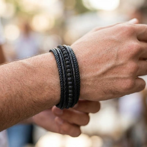 Schwarzes Herren Lederarmband mit Lavastein Naturstein Perlen und geflochtenem Leder am Handgelenk getragen