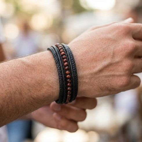 Schwarzes Herren Lederarmband mit braunen Naturstein Perlen und geflochtenem Leder im lässigen Look getragen
