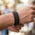 Schwarzes Herren Lederarmband mit braunen Naturstein Perlen und geflochtenem Leder im lässigen Look getragen