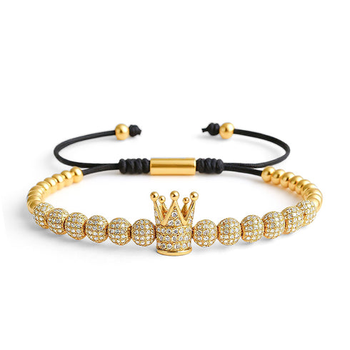 UNIQAL Crown King Armband – luxuriöses Makramee-Armband mit goldenen Kugeln, Krone mit Zirkonia-Steinen und verstellbarem Band. Symbol für Stil & Erfolg.