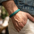 Grünes Lederarmband für Herren im Casual Look mit geflochtener Struktur am Handgelenk getragen