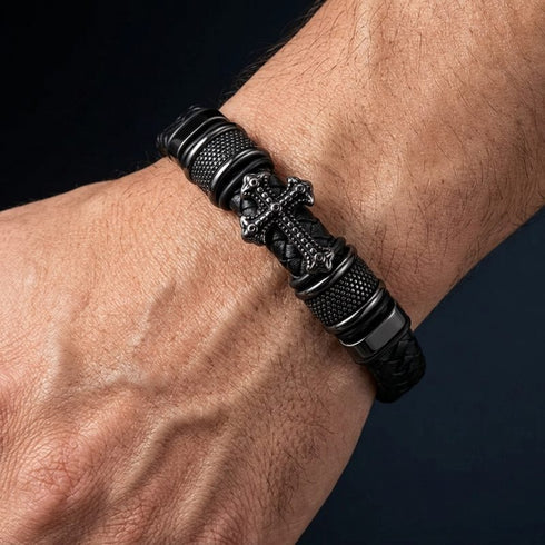 Schwarzes Herren Lederarmband mit Kreuz Motiv, schwarzem Edelstahl und geflochtenem Leder am Handgelenk getragen