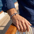 Maritimes Herrenarmband mit Anker Motiv aus Edelstahl und Segeltau am Meer getragen