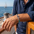 Nautisches Armband für Herren mit Anker Motiv aus Edelstahl und blauem Segelseil getragen