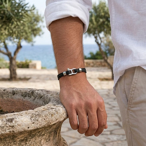 OCEAN SPIRIT Armband am Handgelenk eines Mannes auf Felsen – nautisches Lederarmband UNIQAL