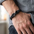 UNIQAL Infinity Black Herren Lederarmband aus schwarzem Leder mit Infinity Symbol am Handgelenk getragen