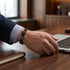 Elegantes Handgelenk mit Uniqal BLACK LABEL beim Arbeiten am Laptop, stilvoll passend zum professionellen Outfit.