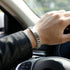 Silberfarbenes Schmuckarmband am Steuer getragen, passend zu selbstbewusstem Auftritt und urbanem Lifestyle.