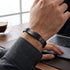 Mann trägt Uniqal VELARO BLACK gravierbares schwarzes Edelstahlarmband am Handgelenk im modernen Business Look.