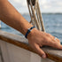 WAVE Armband am Handgelenk einer Frau auf Yacht – maritimes Damenarmband Segeltau UNIQAL