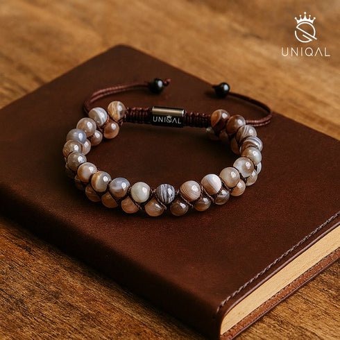 Elegantes Botswana-Achat-Armband auf braunem Ledereinband – Symbol für Erdung, Ruhe und Ausgeglichenheit.