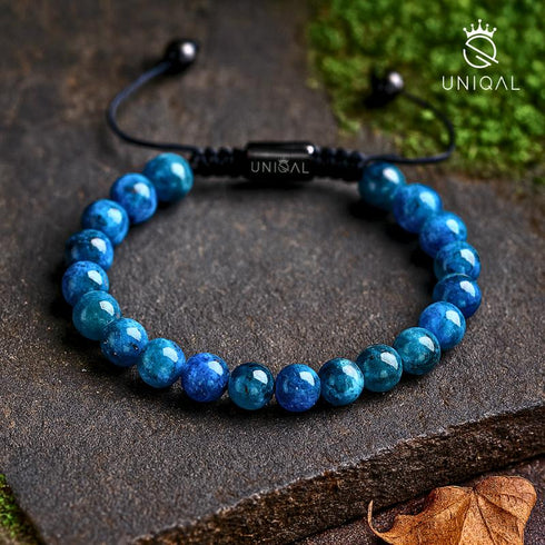 Blaues Apatit-Armband auf dunklem Stein mit Moos – UNIQAL Schmuck in erdiger Umgebung mit Tiefe