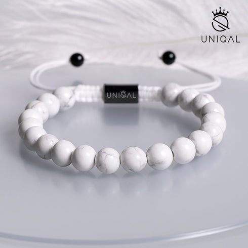 Weißes Howlith-Armband auf glänzendem Untergrund mit Feder – leicht, sanft, hochwertig inszeniert uniqal