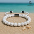 Howlith-Armband am Strand mit türkisblauem Meer im Hintergrund – elegantes Sommer-Accessoire uniqal