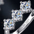 BELLA 925 Silber Creolen – Makroaufnahme der Claw-Fassung mit drei funkelnden Brillantschliff-Moissaniten, schwarzer Hintergrund, Uniqal