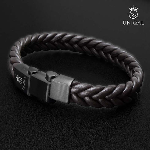BROWN BRAID Lederarmband in liegender ovaler Ansicht mit dunklem Edelstahlverschluss und UNIQAL-Logo auf schwarzer Oberfläche