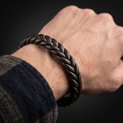 BROWN BRAID Lederarmband am Handgelenk neben einem dunkel karierten Ärmel, mit Blick auf die braune Flechtung