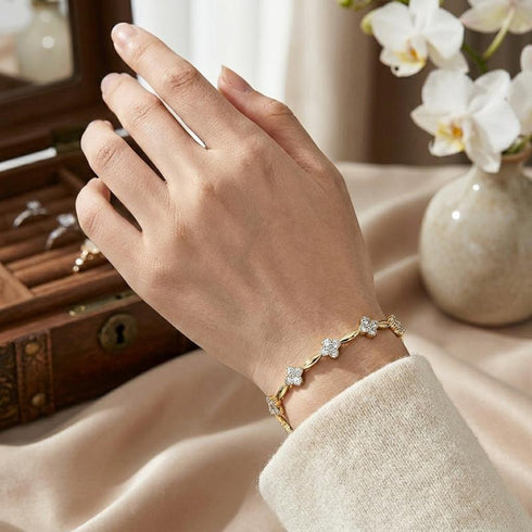 Florales Damenarmband mit Moissanit Steinen am Handgelenk getragen, luxuriöser Schmuck mit goldener Veredelung und femininer Ausstrahlung.