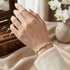 Florales Damenarmband mit Moissanit Steinen am Handgelenk getragen, luxuriöser Schmuck mit goldener Veredelung und femininer Ausstrahlung.