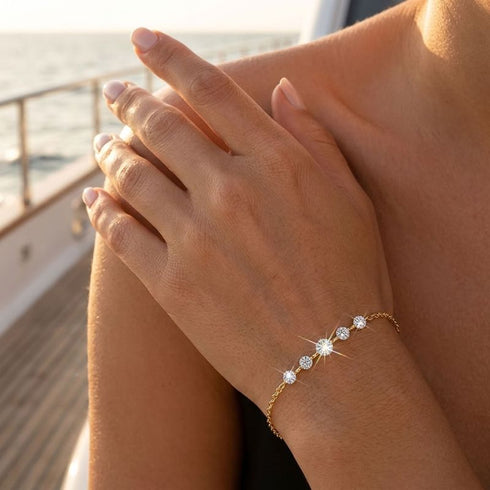 ELARA 14K GOLD von UNIQAL im Abendlicht: feines Moissanit-Kettenarmband am Handgelenk einer Frau, deren Hand auf ihrer Schulter liegt.