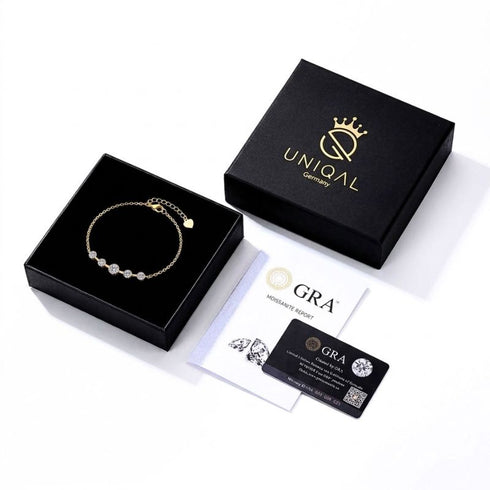 ELARA 14K GOLD Armband im geöffneten UNIQAL Schmucketui, daneben die schwarze Geschenkbox und der GRA-Zertifikat mit Karte.