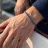 UNIQAL IBIZA Tauarmband mit silberfarbener Kette am Handgelenk zu einem dunkelblauen Oberteil.