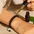 Lavaperlen-Armband wird mit ätherischem Öl beträufelt – Duftarmband für Aromatherapie und Achtsamkeit