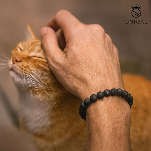 Männerarmband aus Lavastein am Handgelenk mit Katze – Symbol für Stärke, Ruhe und Verbindung zur Natur