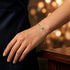 Stilvolles Solitär Armband mit 14K Goldplattierung und funkelndem Edelstein getragen zu eleganter schwarzer Garderobe.