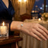 Feines Solitär Armband mit brillantem Moissanit Stein am Handgelenk getragen in stilvoller Abendatmosphäre mit Goldoptik.