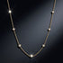 SHINE CELESTA 14K GOLD von UNIQAL als zartes Station-Collier mit sieben gleichmäßig verteilten Edelsteinen und Lichtreflexen vor dunklem Hintergrund.