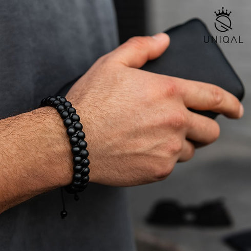Schwarzes Onyx-Perlenarmband von Uniqal am Handgelenk eines Mannes, modern im Streetstyle getragen