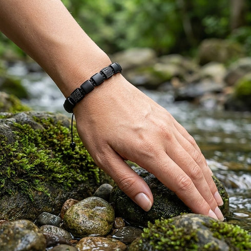 Schwarzes Achat Armband mit Zirkonia Elementen auf Felsen getragen mit klarer Linienführung und möglicher Gravur