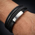 Uniqal BLACK OLIVE Armband mit Gravur am Handgelenk – personalisierbares Herrenarmband mit schwarzem Mehrfachdesign und silberfarbener Gravurplatte.