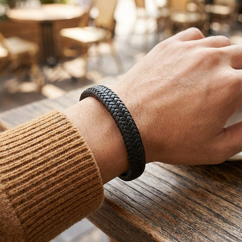 Schwarzes Flechtband am Arm getragen mit personalisierbarer Metalloberflaeche