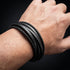 Uniqal BLACKY Herrenarmband – modernes schwarzes Mehrfacharmband am Handgelenk mit geflochtenen Lederakzenten.