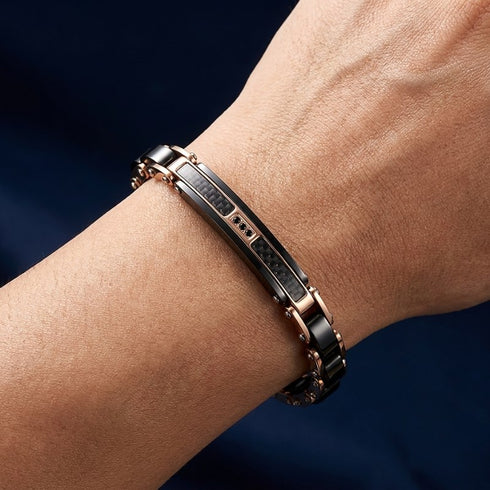 Getragenes UNIQAL CARBONE Edelstahlarmband mit roségoldenen Akzenten und schwarzer Carbonoberfläche, stilvolle Schmuckkreation für Damen und Herren mit zeitgemäßem Charakter