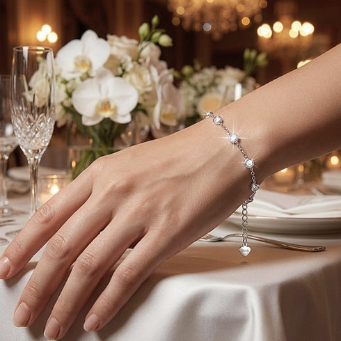 Elegantes CELESTA Damenarmband mit funkelnden Moissanit Steinen neben floralem Arrangement, hochwertiger Schmuck mit Gravur möglich