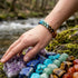 Chakra Edelsteinarmband am Handgelenk in natürlicher Umgebung getragen unisex Schmuckstück mit symbolischer Bedeutung und Gravur möglich