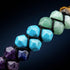 Facettierte Chakra Natursteine in Nahaufnahme mit intensivem Farbverlauf von Rot bis Violett in zweireihigem Edelsteinarmband